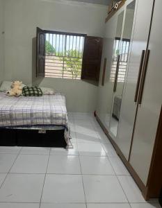 Un dormitorio con una cama y suelo de baldosas. en Casa grande Com 2 quartos e 2 suítes, en Castanhal