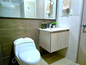 a bathroom with a white toilet and a sink at Moderno y amplio apartamento cerca a centros comerciales in Ibagué +22 photos