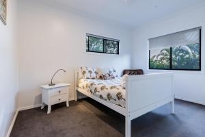 een slaapkamer met een wit bed en een raam bij Shambala Pet Friendly Apartments Agnes Water in Agnes Water