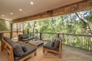 a screened in porch with two couches on a deck at Little Cove 4BR Home, Pool, Pool table, Sleeps 16 in Noosa Heads