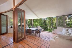 a living room with a white couch and a table at Little Cove 4BR Home, Pool, Pool table, Sleeps 16 in Noosa Heads
