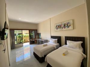 a hotel room with two beds and a television at THE LAVIANA HOTEL in Lovina +64 photos