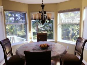 Un comedor con una mesa con un bol de fruta encima. en Sandy's Sweet Home, en Coquitlam