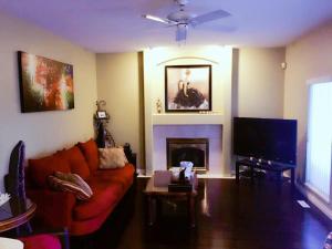 Una sala de estar con un sofá rojo y una chimenea. en Sandy's Sweet Home, en Coquitlam 7 fotos más