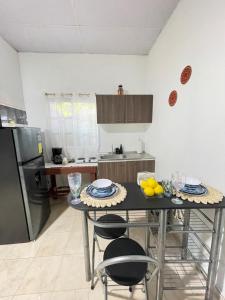 a kitchen with a table with chairs and a refrigerator at La ceibasurf in La Libertad +8 photos