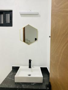 a bathroom with a white sink and a mirror at JiuteHaus 7 in Jiutepec