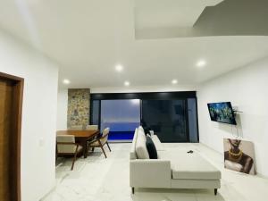 ein Wohnzimmer mit einem weißen Sofa und einem Tisch in der Unterkunft JiuteHaus 7 in Jiutepec