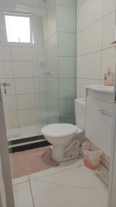 a white bathroom with a toilet and a window at Apartamento Solar dos Pampas in Guaíba +5 photos