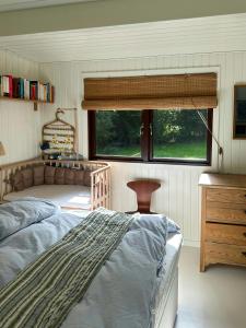a bedroom with a bed and a window at Nordic-Style Summer House At Asserbo Plantage in Melby