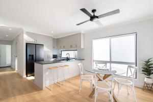 a kitchen and dining room with a table and chairs at Bay Breeze Beachhouse in Scarness