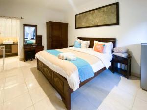 a bedroom with a large bed with towels on it at Sans Vibes Tendan Residence Kuta in Legian +19 photos