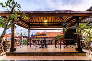 a pavilion with chairs and a table on a deck at Sans Vibes Tendan Residence Kuta in Legian