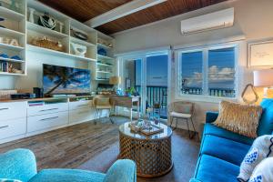 un salon avec un canapé bleu et une table dans l'établissement Pohailani Paradise, AC, Ocean Views, Sunsets, à Lahaina