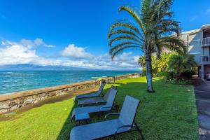 une rangée de chaises bleues assises à côté de l'océan dans l'établissement Pohailani Paradise, AC, Ocean Views, Sunsets, à Lahaina