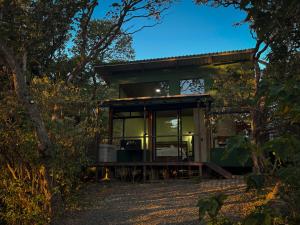 une maison en verre dans les bois la nuit dans l'établissement Monte Green Villa Romántica con jacuzzi, à Monteverde Costa Rica