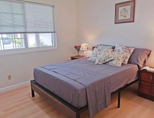 1 dormitorio con 1 cama grande con almohadas y ventana en Tranquil Fremont Getaway - Comfortable 3BR 2BA Home, en Fremont 1 foto más