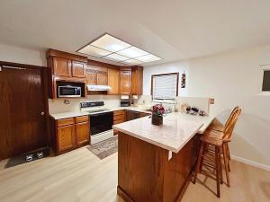 cocina con armarios de madera y encimera blanca en Tranquil Fremont Getaway - Comfortable 3BR 2BA Home, en Fremont