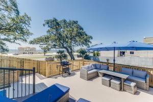 a patio with chairs and an umbrella and a table at Front row Seat at 'The Sandy Rose' in Biloxi