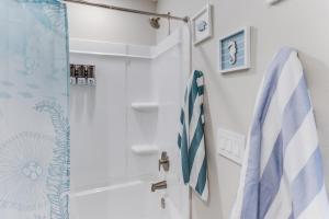 a bathroom with a shower with blue and white towels at Front row Seat at 'The Sandy Rose' in Biloxi +18 photos