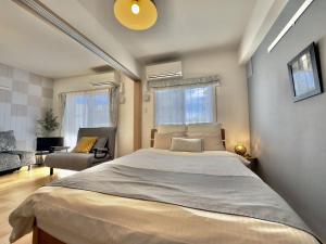 a bedroom with a large bed and a living room at Luana Lea Karate Kaikan Mae in Tomigusuku