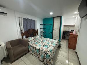 a bedroom with a bed and a chair in it at Apartamentos Zamora in Puerto Limón +21 photos