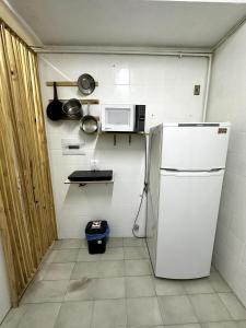 Una cocina con un refrigerador blanco y un microondas. en Quarto Privativo Leme de Noronha - 2Min da praia, en Río de Janeiro