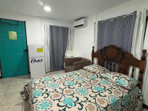 a bedroom with a bed and a chair and a door at Apartamentos Zamora in Puerto Limón