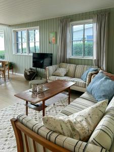 a living room with a couch and a coffee table at Holiday Home With Sea View Near Hesselager in Hesselager