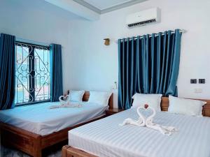 two beds in a room with two swans on them at Tam Coc White Swan Homestay in Ninh Binh