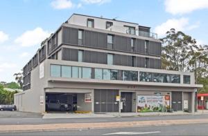 a large building on the corner of a street at Cozy Stay Near CBD Free Wi-Fi, Netflix & Parking in Beecroft
