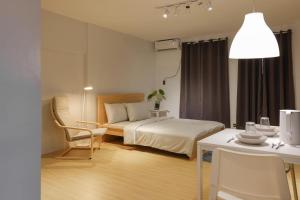 a bedroom with a bed and a table and chair at Siesta Spaces Boracay in Boracay