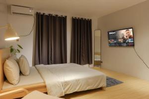 a bedroom with a bed and a flat screen tv at Siesta Spaces Boracay in Boracay