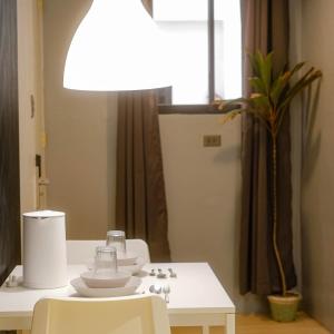 a white table with chairs and a light on it at Siesta Spaces Boracay in Boracay