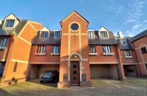 un bâtiment en briques avec une voiture garée devant dans l'établissement Stylish 1 Bedroom Apartment with Free Parking and Links to London & Essex, à Stifford