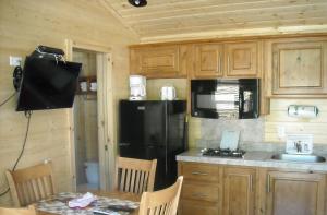 uma cozinha com um frigorífico preto e uma mesa em Yosemite Lakes Wheelchair Accessible Cottage 53 em Harden Flat