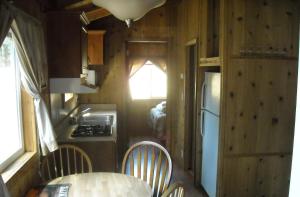uma cozinha com mesa e cadeiras numa pequena casa em Yosemite Lakes Cabin 37 em Harden Flat