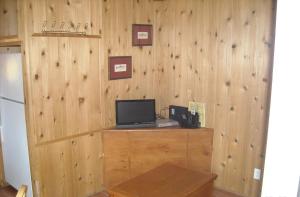 Cette chambre dispose d'un mur en bois et d'un bureau avec un ordinateur. dans l'établissement Yosemite Lakes Cabin 39, à Harden Flat