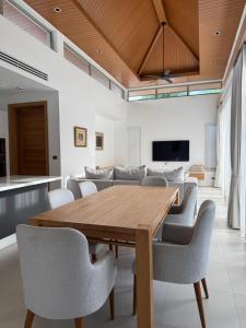 a dining room with a wooden table and chairs at Luxury Villa Phuket in Phuket
