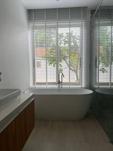 a bathroom with a tub and a window with a tree at Luxury Villa Phuket in Phuket