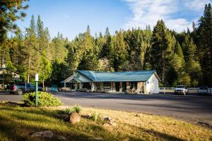 un edificio junto a una carretera con árboles en Yosemite Lakes Bunkhouse Cabin 34, en Harden Flat