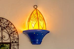 a blue light fixture hanging on a wall at Hotel Los Castaños in Cartajima