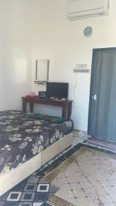 チャンルーンにあるVilla Cempaka Homestayのベッドルーム1室(ベッド1台、ノートパソコン付きのデスク付)