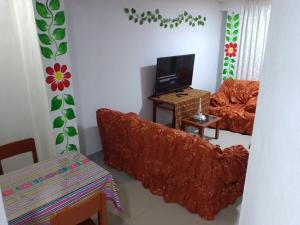 Una sala de estar con un sofá y un televisor. en Condominio Las Torres, en Ayacucho