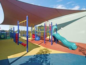 a childrens playground with a slide and a play structure at Nomikis'On The Avenue in Paraparap