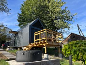 a tiny house with a deck on a yard at La - Mai Glamping in Žetale