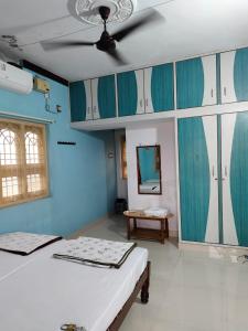 Dos camas en una habitación con paredes y techo azules. en Tanvi Guest House Hampi, en Hampi
