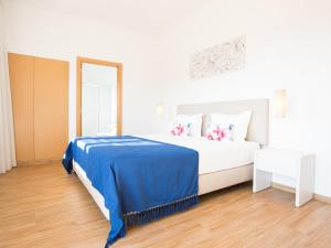 a bedroom with a bed with a blue blanket at Tavira Monte in Tavira