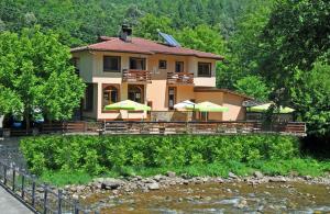 ein Haus auf einer Brücke über einen Fluss in der Unterkunft Family Hotel Fedora in Ribarica + 110 Fotos