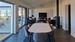 a living room with a white table and chairs at Modern Lake House With Spa At Lake Barken in Sörbo