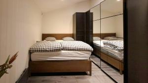 two twin beds in a room with a mirror at Modern Lake House With Spa At Lake Barken in Sörbo